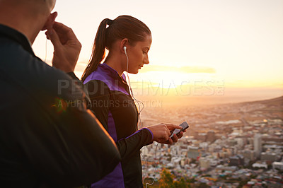 Buy stock photo Couple, fitness and music with phone in sunset for podcast, radio player or sound on mountain. Man and woman listening to audio or streaming before workout, exercise or outdoor training in nature