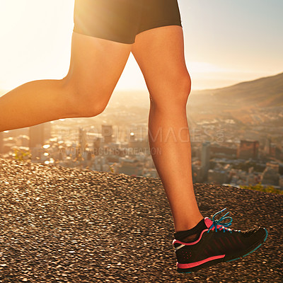 Buy stock photo Legs, sneakers and person running outdoor in city, cardio and fitness for health and wellness at sunrise. Athlete, marathon and speed with runner on road for exercise, workout and training in morning