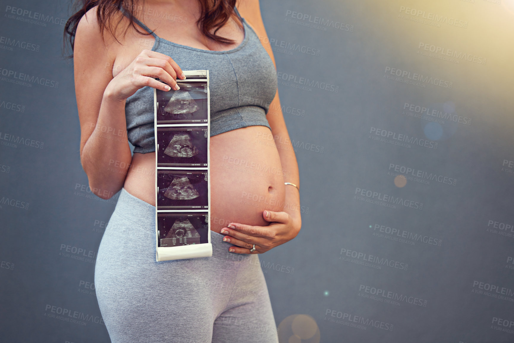 Buy stock photo Woman, pregnant and holding belly with sonogram in studio for maternity shoot, album and baby shower. Mother, growth and ultrasound isolated on gray background for gender reveal and surrogacy