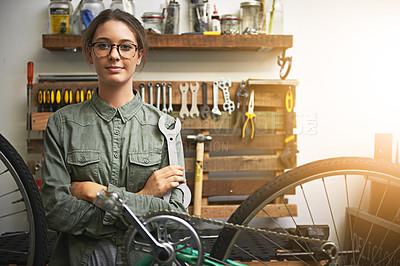 Buy stock photo Portrait of a confident young woman working in a bicycle repair shop