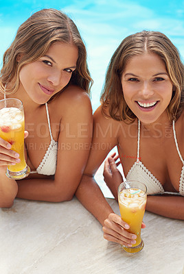 Buy stock photo Portrait of twin sisters relaxing with drinks in a swimming pool