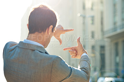 Buy stock photo Shot of a businessman framing a city scene with his hands