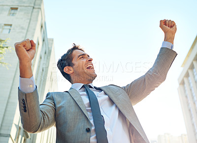 Buy stock photo Shot of a businessman celebrating a success in an urban setting