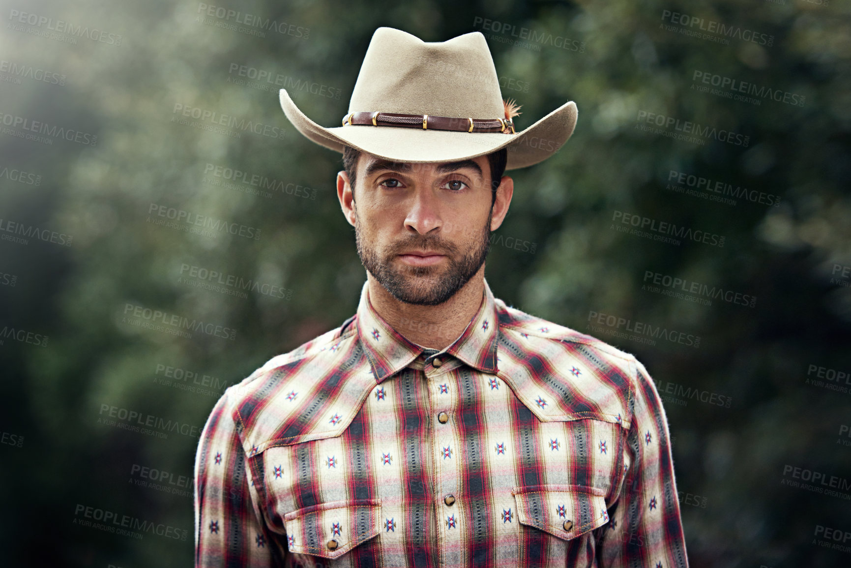 Buy stock photo Man, portrait and outdoor cowboy clothes, western culture and countryside ranch in Texas. Male person, hat and flannel fashion for farmer aesthetic, nature and plaid style by trees or outside bush