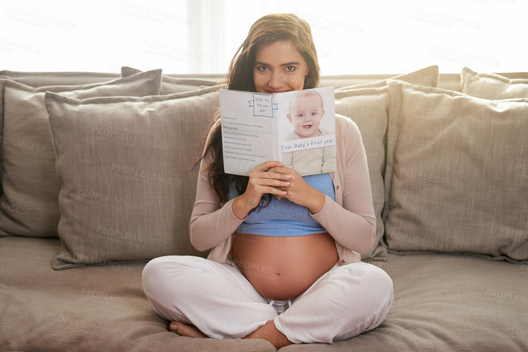 Buy stock photo Shot of a young pregnant woman reading a baby book at home