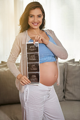 Buy stock photo Portrait of a pregnant woman showing you a sonogram picture at home