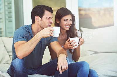 Buy stock photo Couple, morning and coffee on sofa in home for smile, thinking or relax with drink. Man, woman and happy for conversation with latte, coco or tea cup for bonding, love and idea on vacation with couch