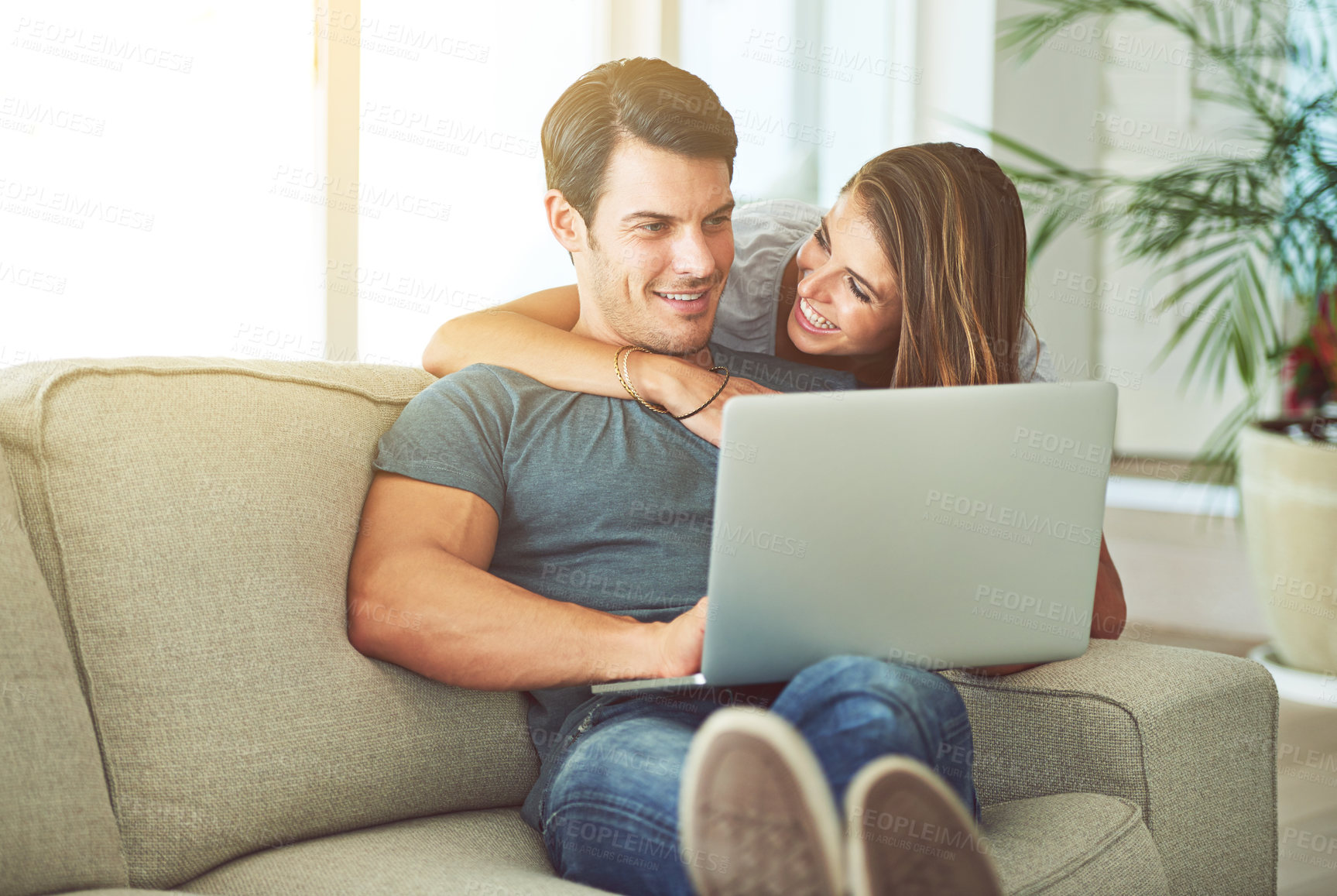 Buy stock photo Computer, smile and woman hugging man on sofa networking on social media, website or internet. Happy, love and female person embracing husband reading online blog with laptop in living room at home.