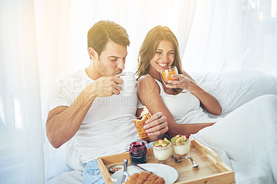 Buy stock photo Shot of a loving young couple enjoying breakfast in bed
