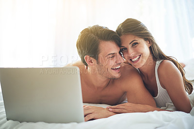 Buy stock photo Laptop, happy and couple lying in bed together while watching a online movie or video at their home. Happiness, smile and portrait of a woman browsing the internet on computer with husband in bedroom