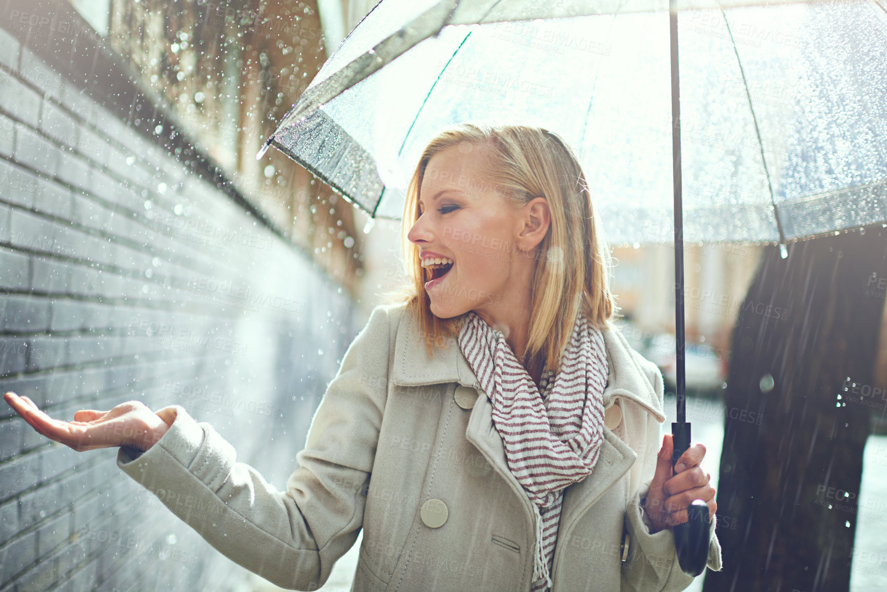 Buy stock photo Smile, happy woman and rain feeling water in the city with umbrella, freedom and happiness. Winter weather, raining and urban street with a young female person on a sidewalk and vacation outdoor