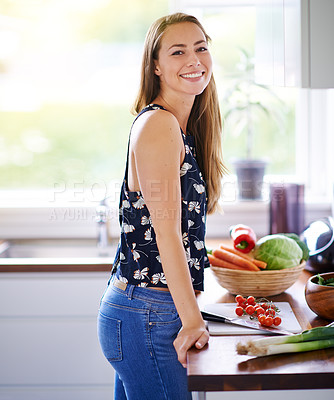 Buy stock photo Shot of a young woman preparing a meal in her kitchen