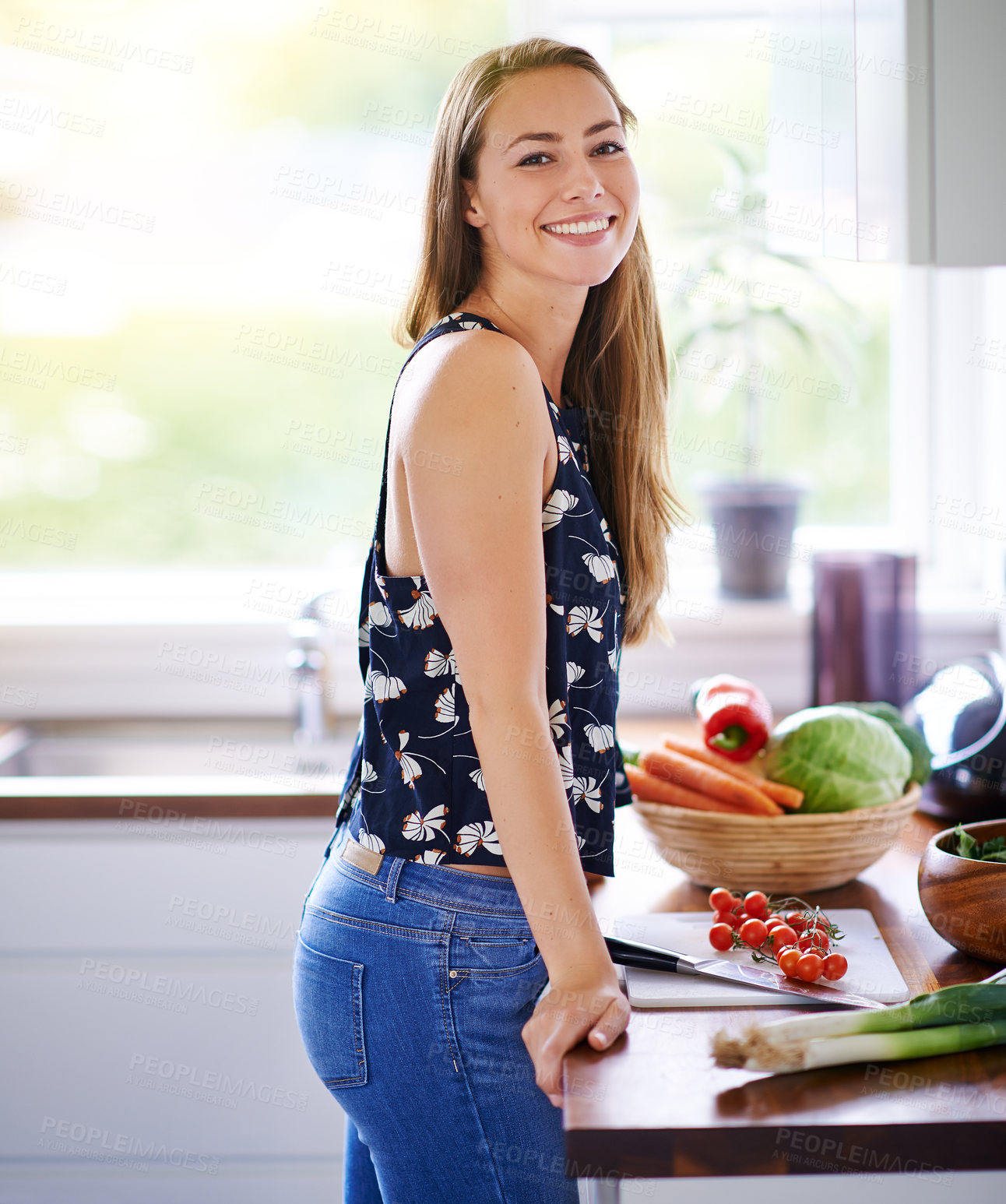 Buy stock photo Shot of a young woman preparing a meal in her kitchen