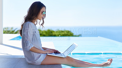 Buy stock photo Shot of a young woman using her  laptop by the poolside