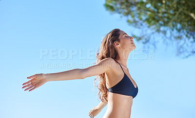 Buy stock photo Shot of a young woman relaxing poolside