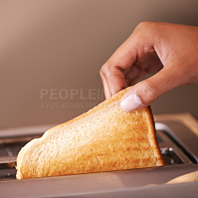 Buy stock photo Cropped shot of a woman taking toast out of a toaster