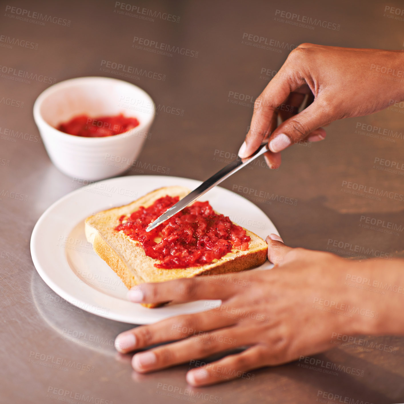 Buy stock photo Cropped shot of a woman spreading fruity jam onto toast