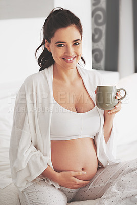 Buy stock photo Shot of a pregnant woman relaxing with a beverage at home