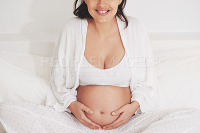 Buy stock photo Woman, home and pregnant with smile in bed for child, expecting and satisfied in bedroom. Female person, maternity and touching stomach in sleepwear with happiness, pride and joy as mother with care