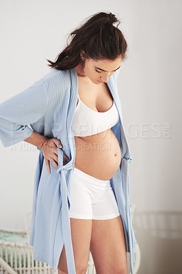 Buy stock photo Shot of a pregnant woman looking down at her belly