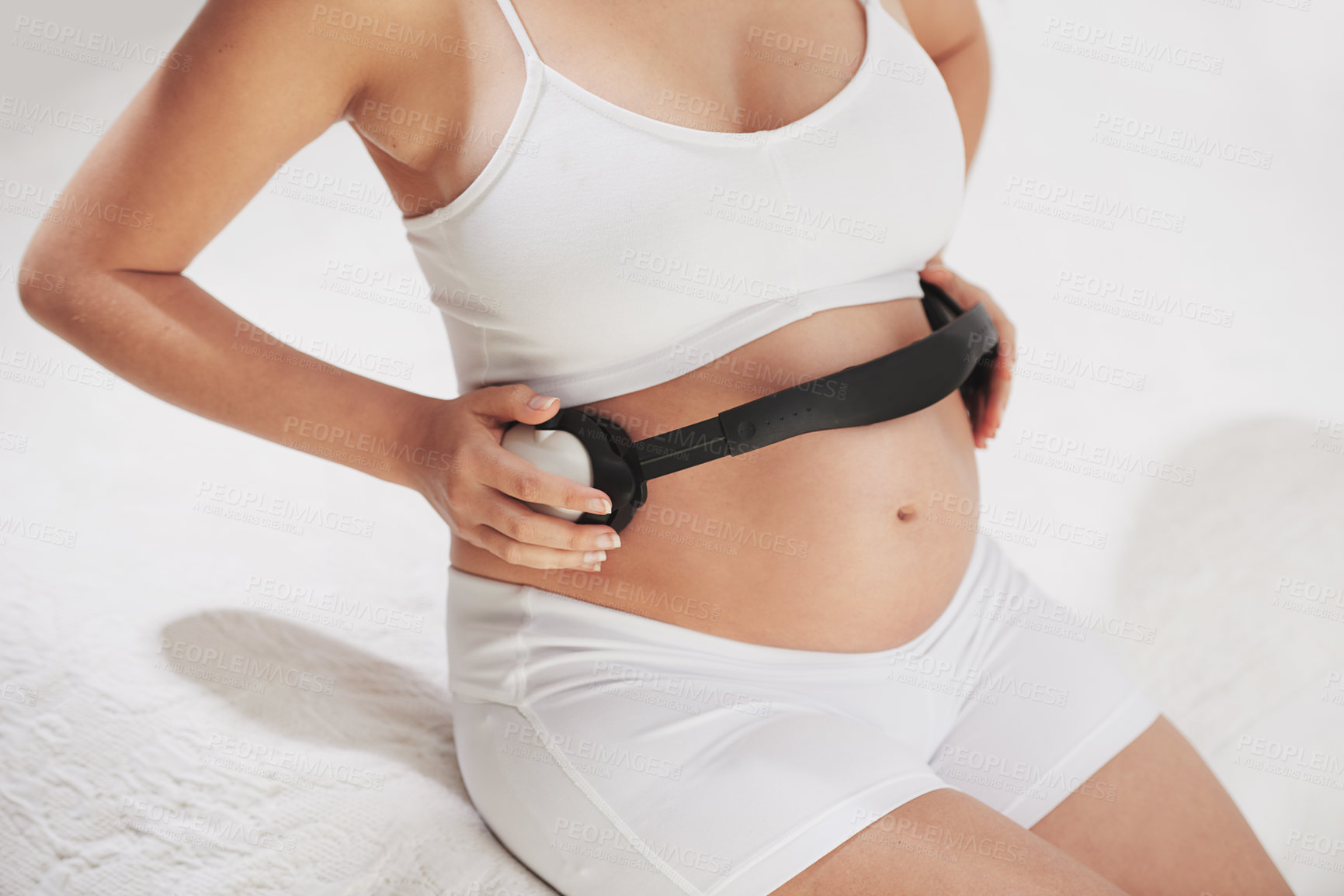 Buy stock photo Cropped shot of a pregnant woman holding headphones around her belly