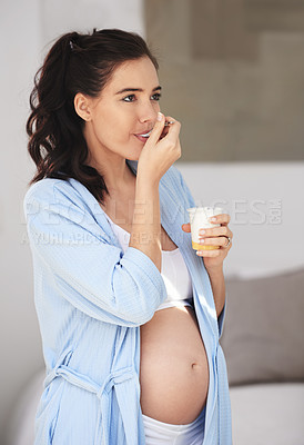 Buy stock photo Pregnancy, eating and woman at home with yogurt for snack, craving and nutrition in bedroom. Pregnant person, abdomen and dessert or ice cream for vitamin, protein and wellness for belly or stomach