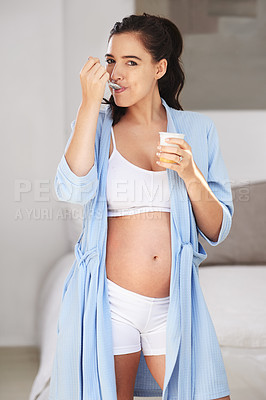 Buy stock photo Pregnancy, portrait and girl in home with yogurt for snack, craving and nutrition in bedroom. Pregnant woman, abdomen and dessert or ice cream for vitamin, protein and wellness for belly or stomach