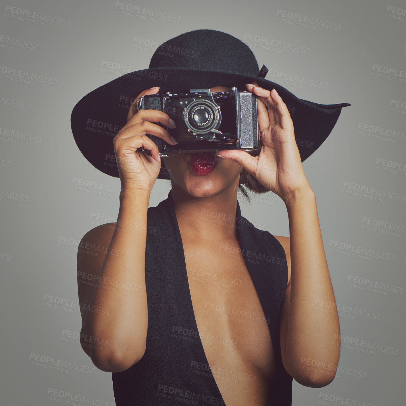 Buy stock photo Studio shot of a stylishly dressed young woman holding a vintage camera