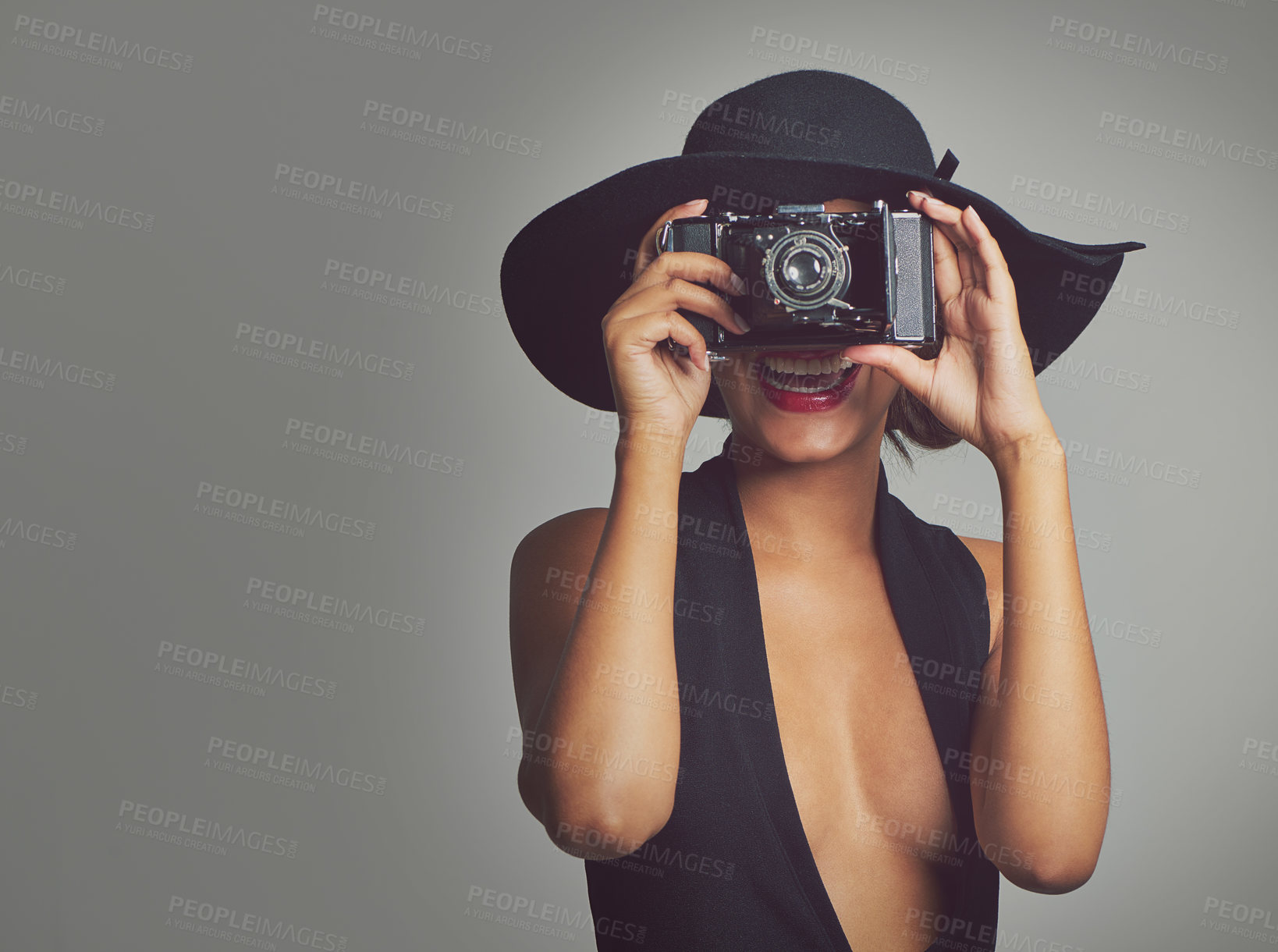 Buy stock photo Fashion, camera and elegant woman in hat, studio and smile isolated on gray background. Face, confident and style for summer outfit, classy aesthetic and clothes with glamour cosmetics in Brazil