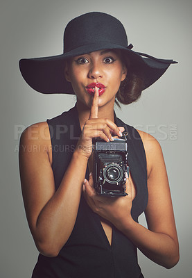 Buy stock photo Fashion, portrait and camera for woman, hat and studio on gray background. Face, confident and gesture for secret with summer style outfit, classy aesthetic or clothes with glamour cosmetic in Brazil