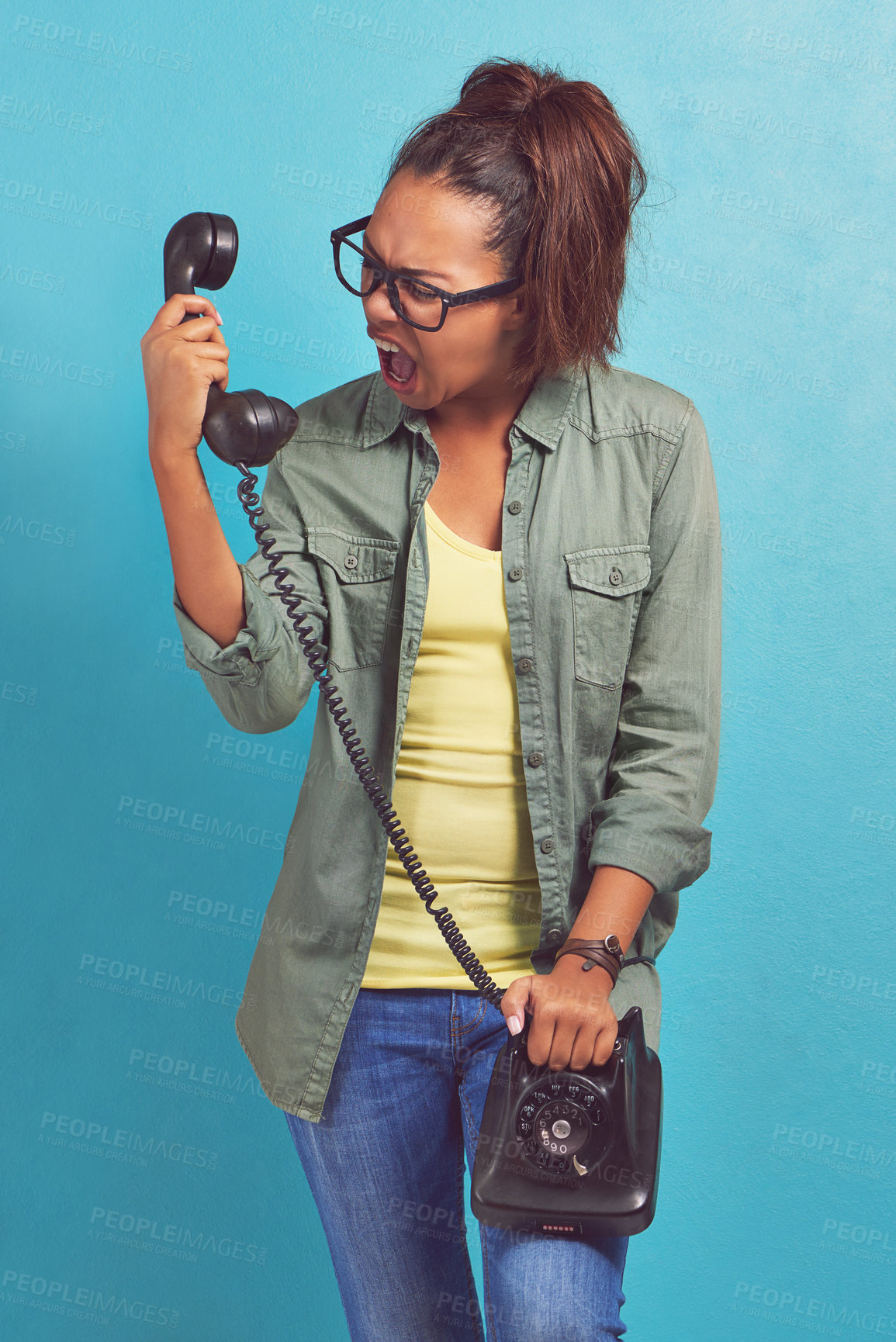 Buy stock photo Telephone, angry and shouting with woman, stress and frustrated on blue studio background. Person, furious and girl with communication, rude or upset with emotion, screaming and aggressive with model