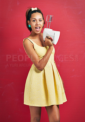 Buy stock photo Happy woman, portrait and baker with electric mixer for ingredients or desert on a red studio background. Young female person with surprise for home appliance, baking or hospitality in yellow dress