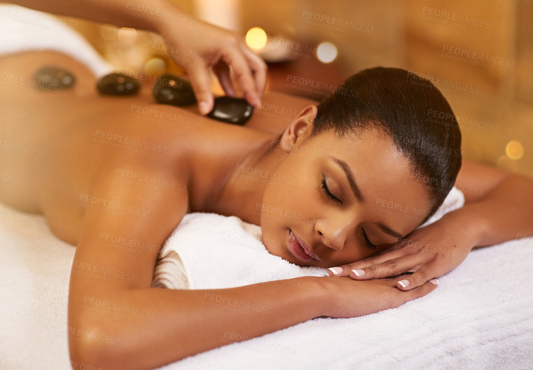 Buy stock photo Spa, stone and woman with massage, wellness and relaxing with stress relief, skincare and vacation. Person, resort and girl with health, treatment and calm with zen therapy masseuse and body luxury