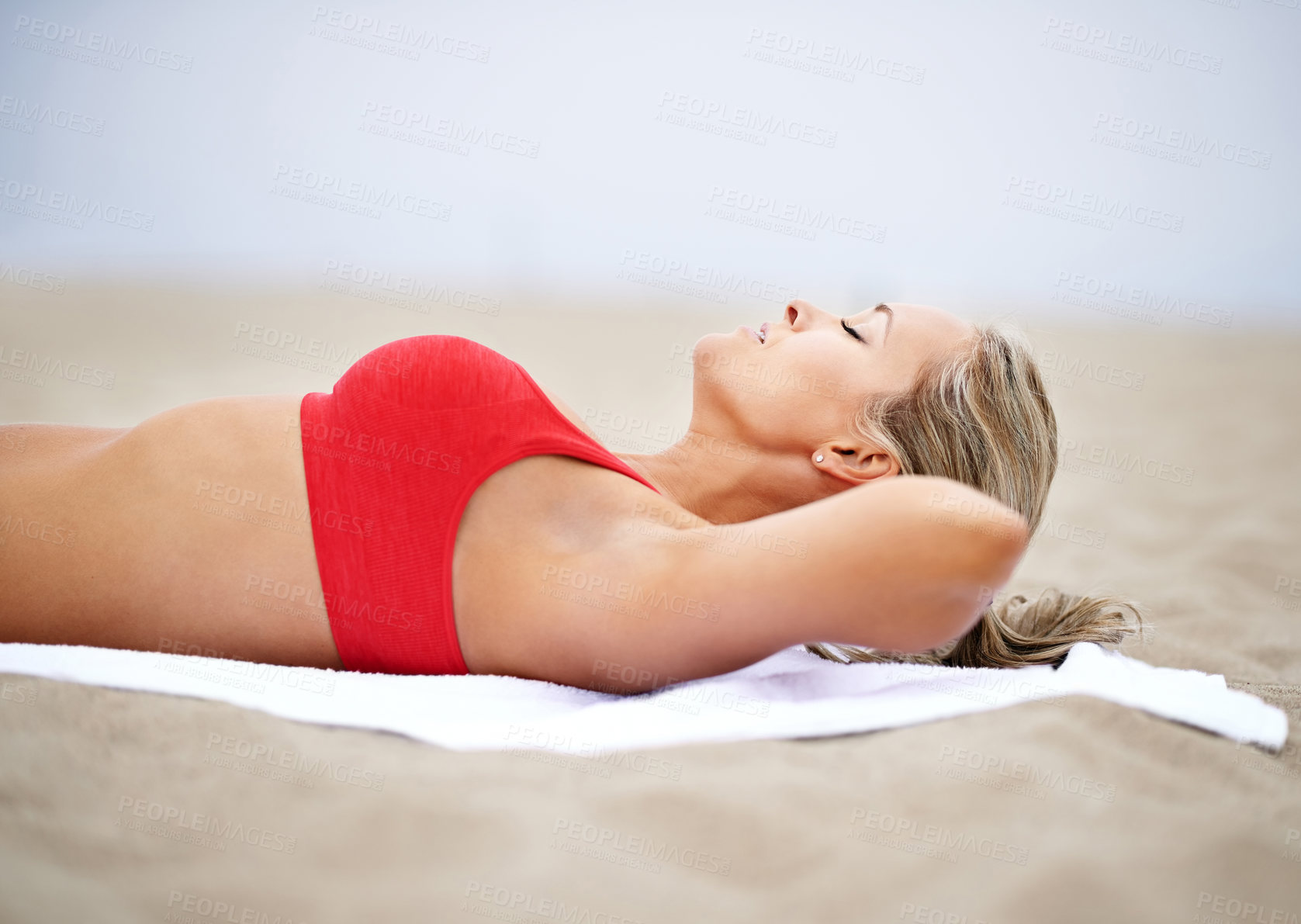 Buy stock photo Woman, sleeping and relax in beach to tan with towel outdoors, resting and enjoying sunshine or fresh air. Female person, sand and eyes closed for break, body health and wellness as hobby on holiday