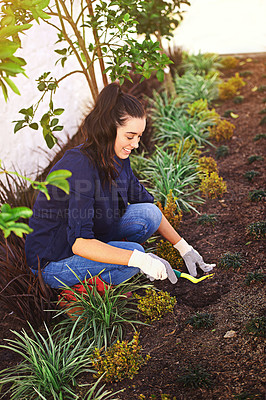 Buy stock photo Shot of a young woman working in her garden