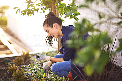 Buy stock photo Shot of a young woman working in her garden