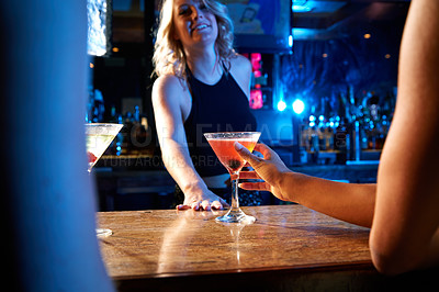 Buy stock photo Bartender, nightclub and cocktail drink with mixologist worker at counter serving alcohol at a restaurant, bar or new years party. Hand of woman on glass for drinking, celebration and service