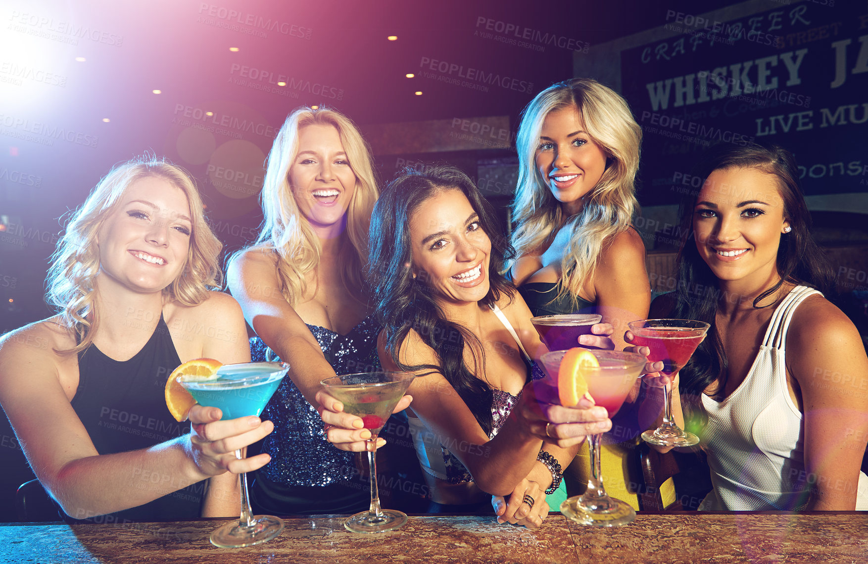 Buy stock photo Shot of young women drinking cocktails in a nightclub