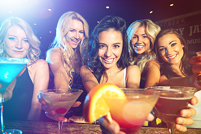 Buy stock photo Shot of young women drinking cocktails in a nightclub