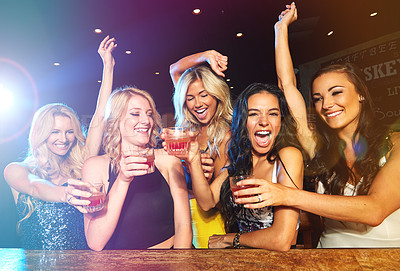 Buy stock photo Shot of young women drinking cocktails in a nightclub