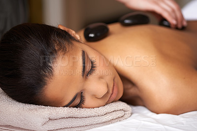 Buy stock photo Woman, hands or back massage with rocks in spa to relax for zen, sleeping or wellness physical therapy. Girl, rest or calm client in salon to exfoliate for body healing treatment or hot stone therapy