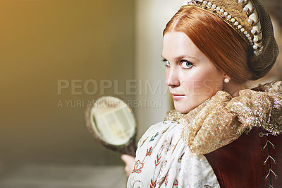 Buy stock photo Shot of an elegant noble woman admiring herself in a mirror in her palace room