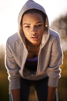 Buy stock photo Shot of a young woman taking a breather while out for a run