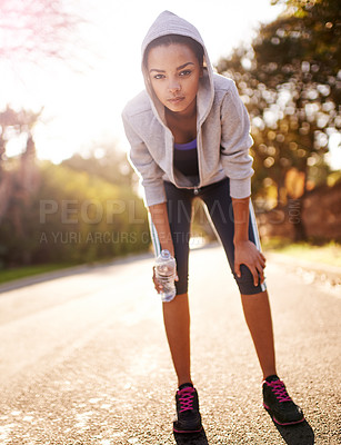 Buy stock photo Shot of a young woman taking a breather while out for a run