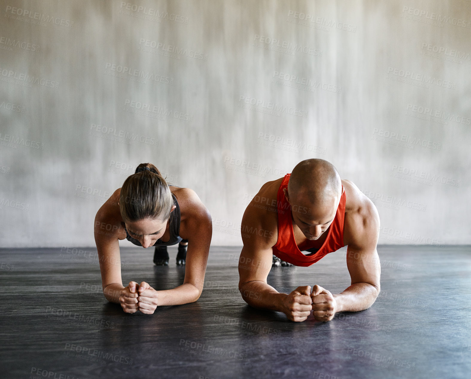 Buy stock photo Shot of two people doing plank exercises at the gym