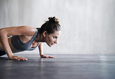 Buy stock photo Shot of a woman doing push-ups at the gym