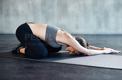 Buy stock photo Shot of a young woman doing yoga at the gym