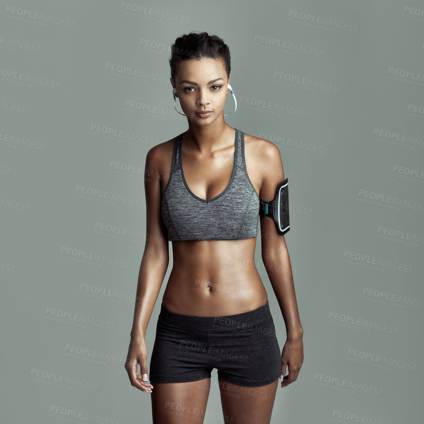 Buy stock photo Portrait, workout and woman with earphones in studio for streaming music, motivation podcast or fitness playlist. Grey background, exercise and female athlete for cardio, running or physical training