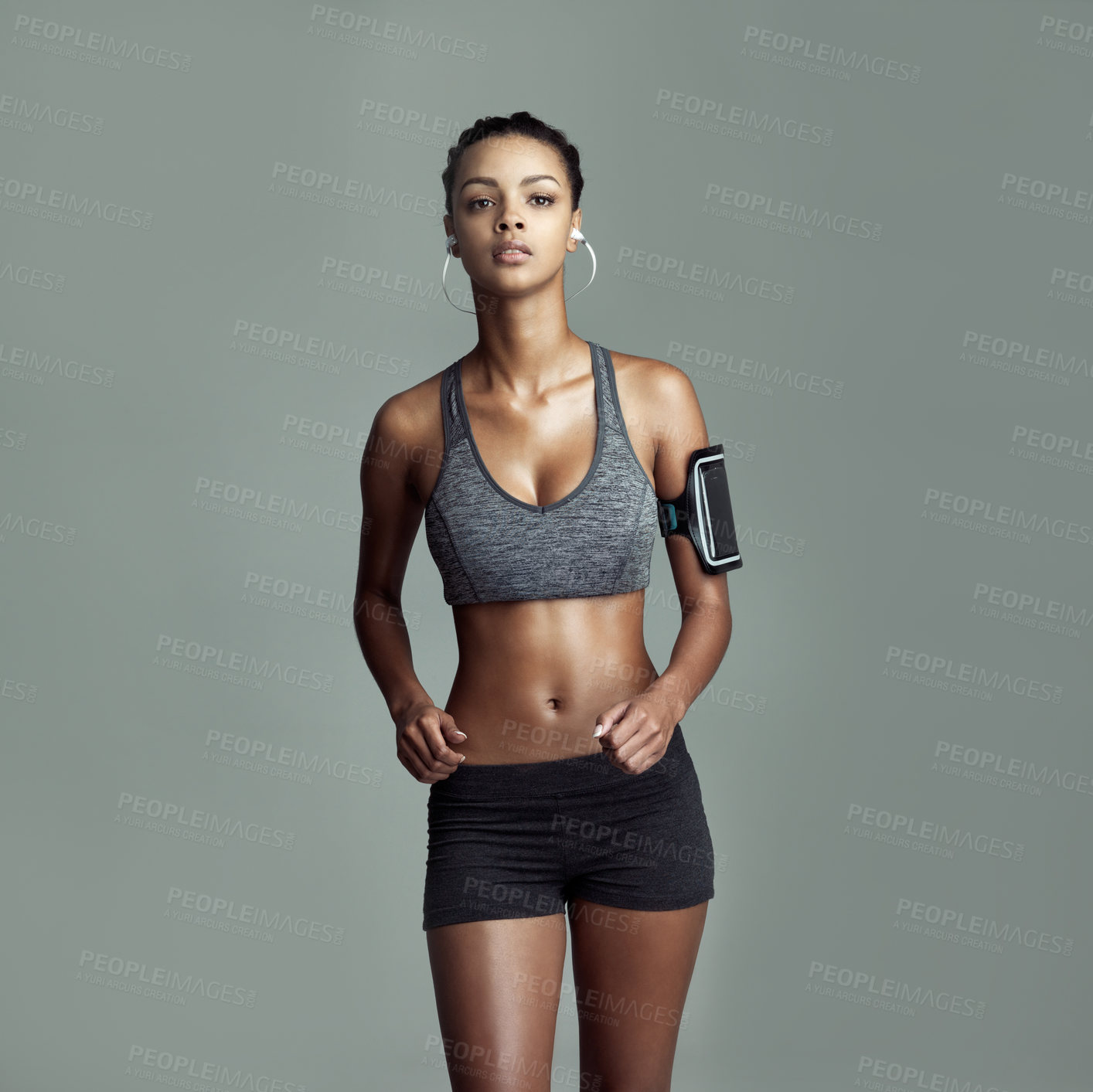 Buy stock photo Fitness, portrait and woman with headphones in studio for sports, exercise and listening to music. Serious, workout and runner with technology on gray background for training, podcast or healthy body