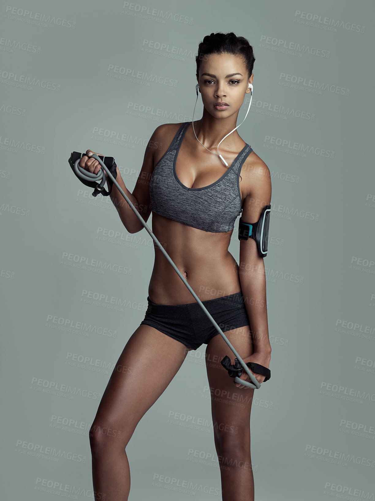 Buy stock photo Jump rope, music and training with portrait of woman in studio isolated on gray background. Exercise, fitness and skipping with serious athlete at gym for health, performance or workout challenge